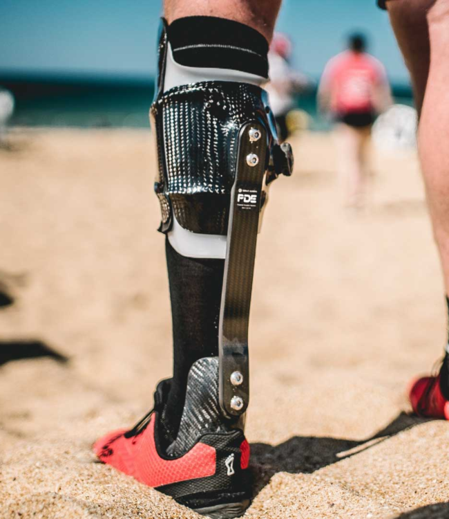 Runner with a prosthetic running blade on the beach